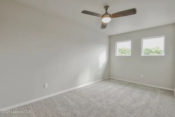 an empty room with a window and a fan