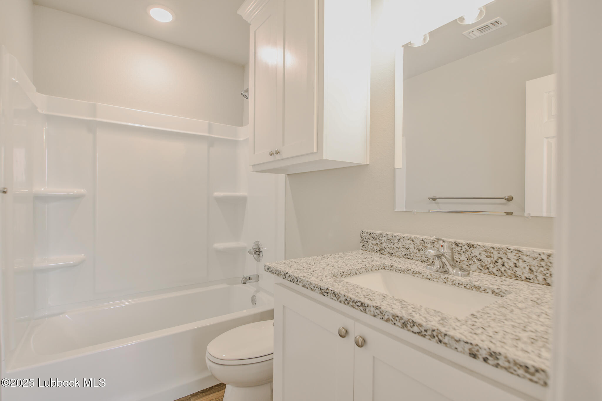 3119 74th Street Lubbock, TX 79423 - Photo 32 of 36 a bathroom with a granite countertop sink a toilet and bathtub