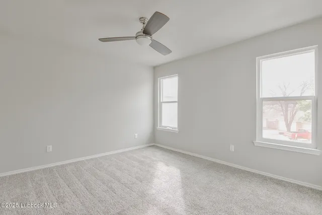 an empty room with a window and ceiling fan