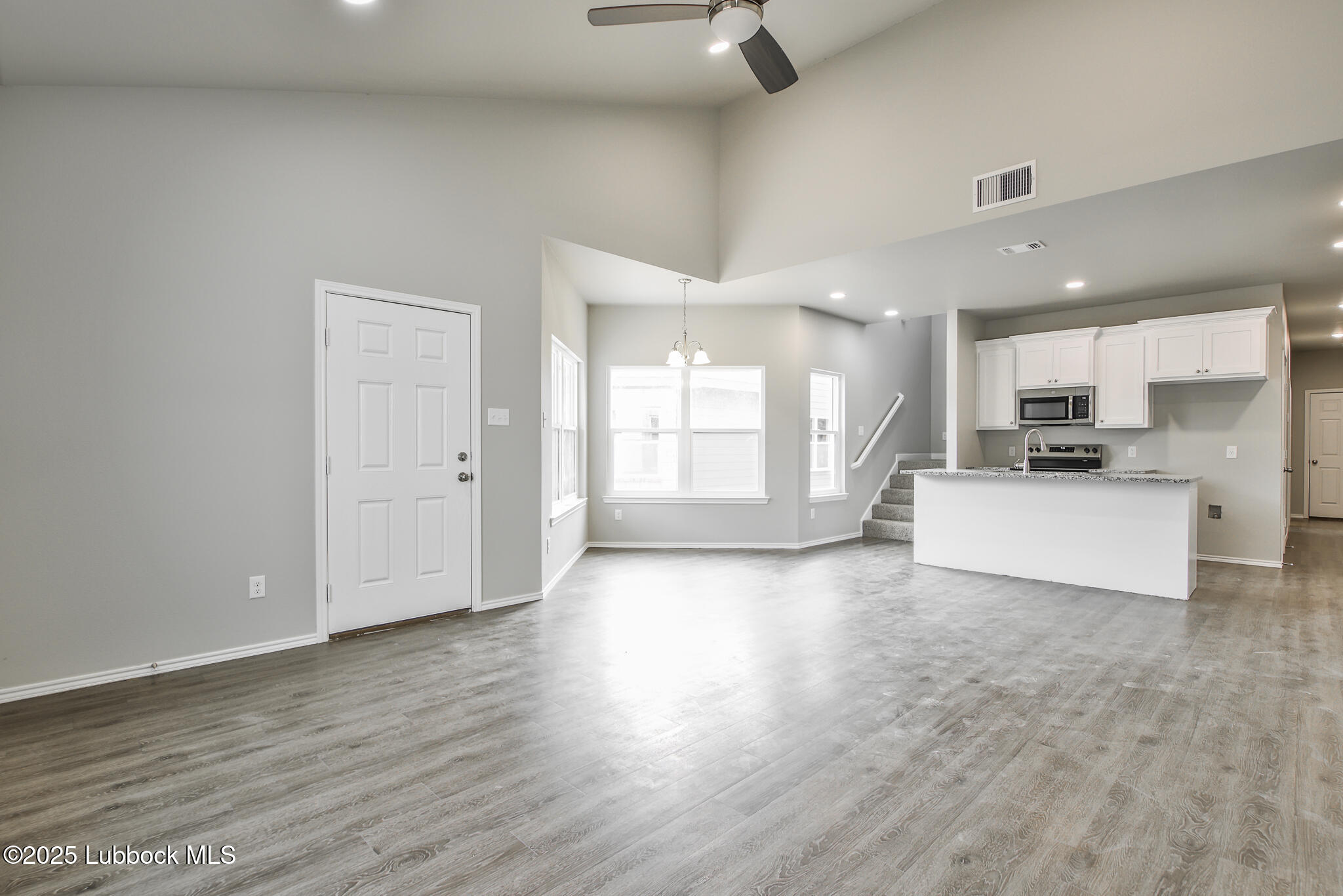 3119 74th Street Lubbock, TX 79423 - Photo 5 of 36 a view of a kitchen with a stove cabinets and wooden floor