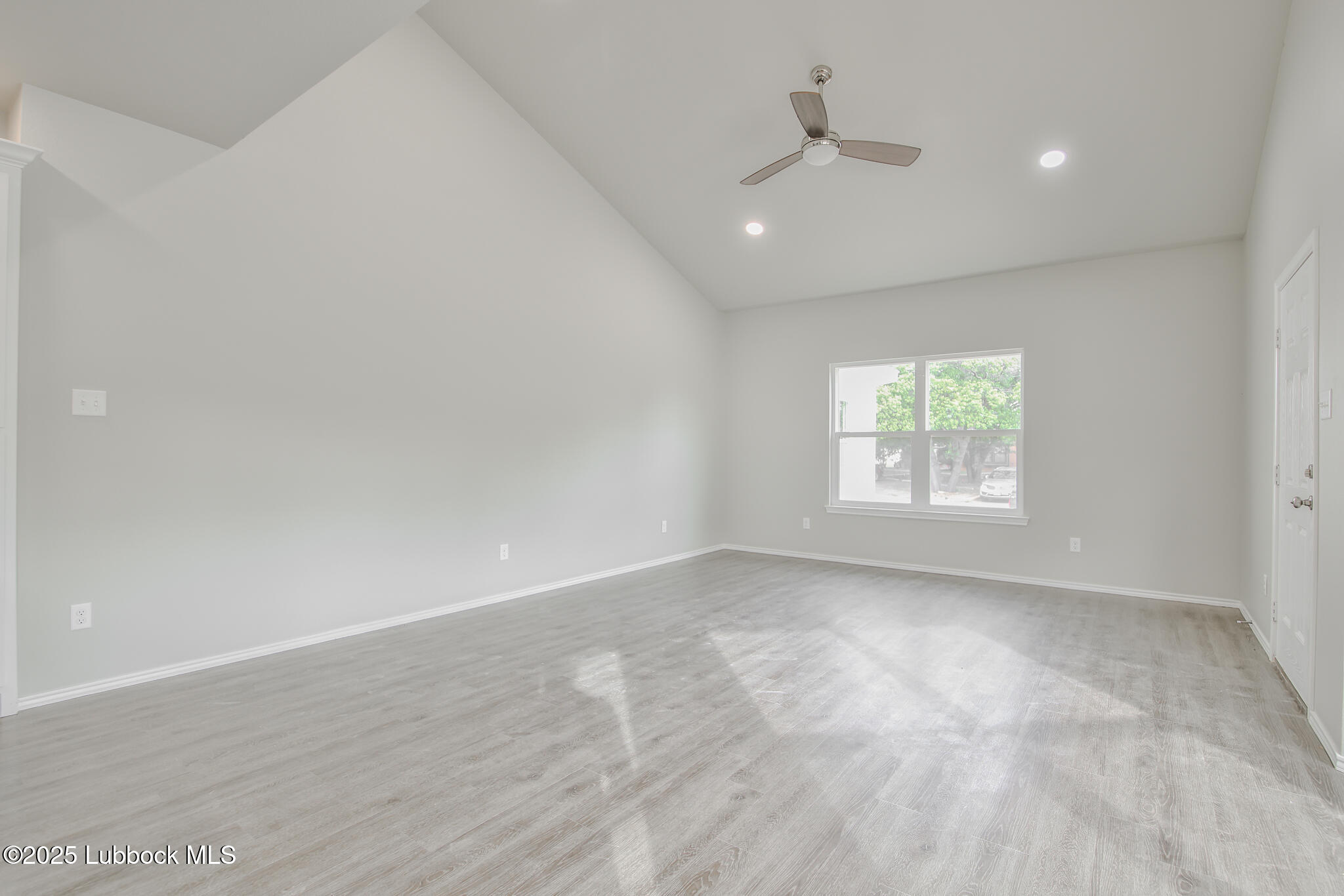 3119 74th Street Lubbock, TX 79423 - Photo 7 of 36 an empty room with a window and a ceiling fan