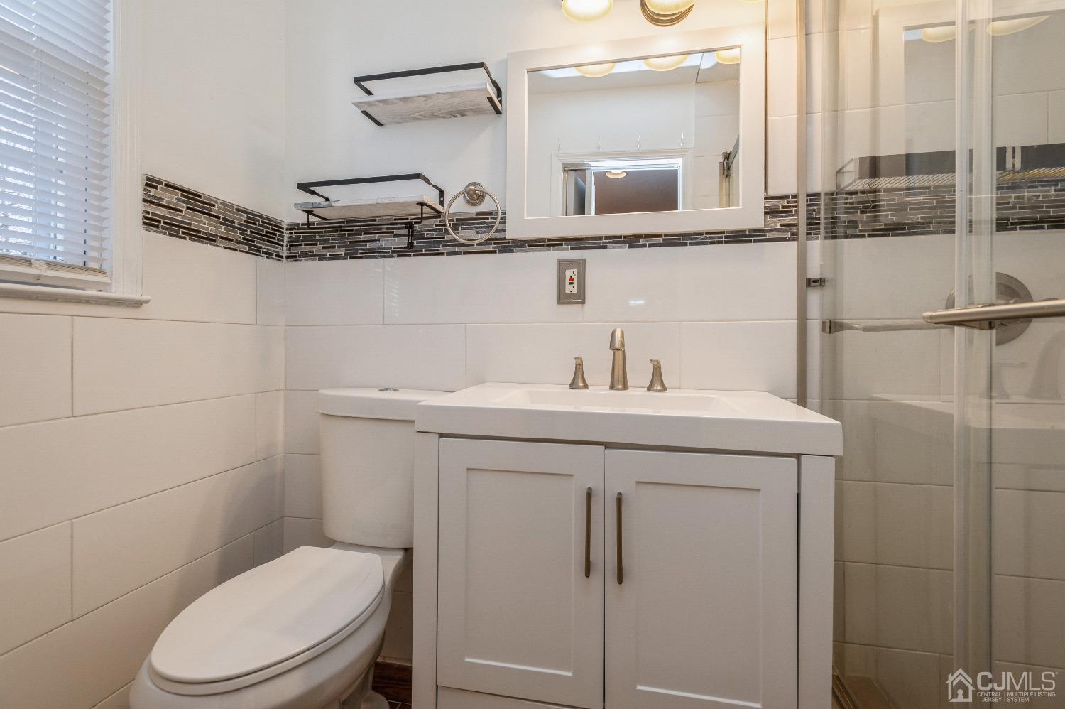 2 Sherwood Road Edison, NJ 08820 - Photo 17 of 26 a bathroom with a sink a toilet and mirror