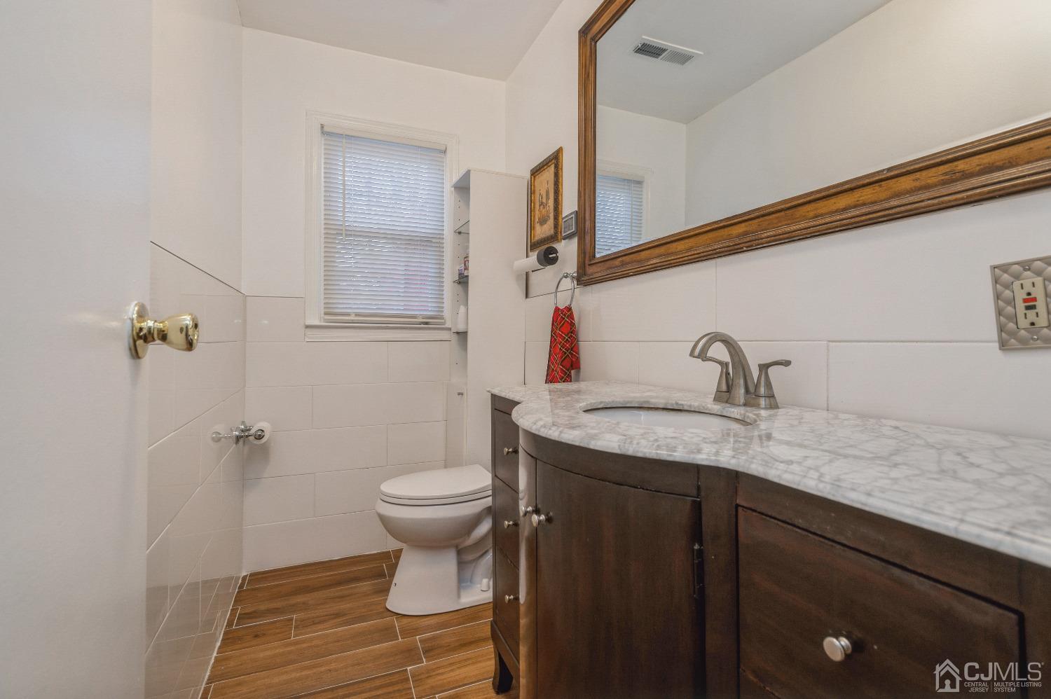 2 Sherwood Road Edison, NJ 08820 - Photo 23 of 26 a bathroom with a granite countertop sink a toilet and a mirror