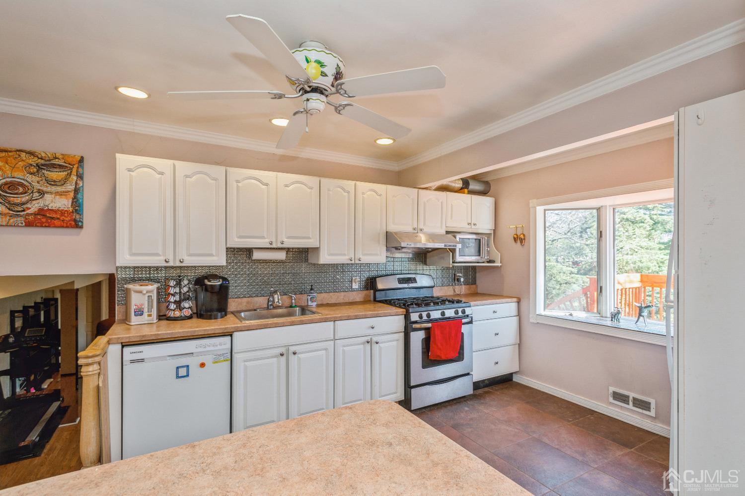 2 Sherwood Road Edison, NJ 08820 - Photo 10 of 26 a kitchen with stainless steel appliances a sink a stove a refrigerator cabinets and a window