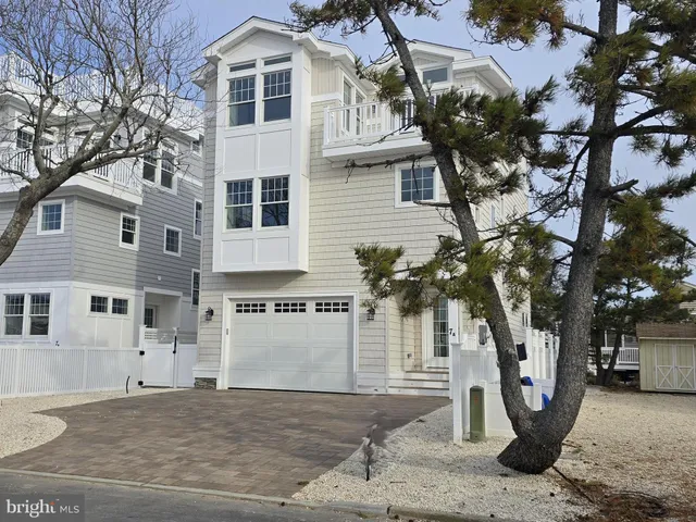 a front view of a house with a tree