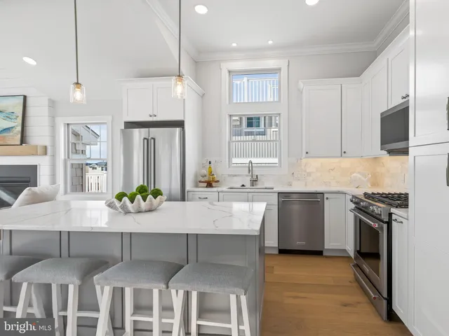 a large kitchen with kitchen island a large counter space dining table and stainless steel appliances