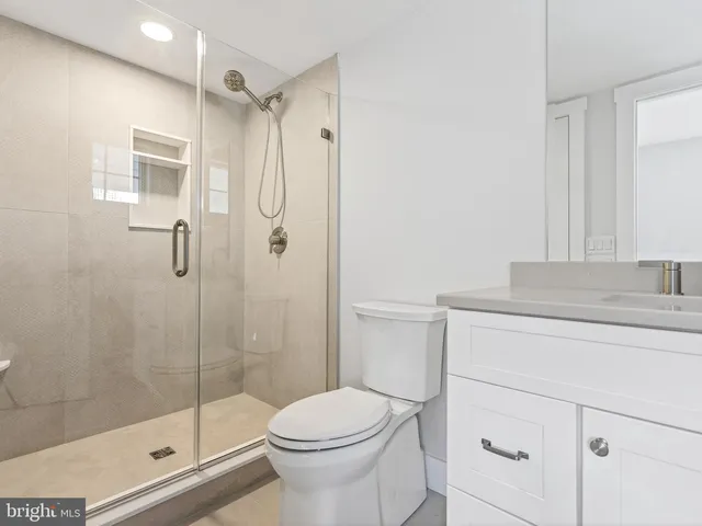 a bathroom with a granite countertop sink toilet and shower