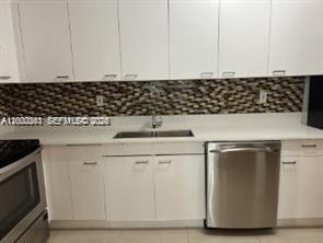 9341 Collins Avenue, Unit 604 Surfside, FL 33154 - Photo 6 of 15 a kitchen with a sink and cabinets