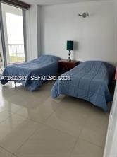 9341 Collins Avenue, Unit 604 Surfside, FL 33154 - Photo 8 of 15 a bedroom with a bed and a chair