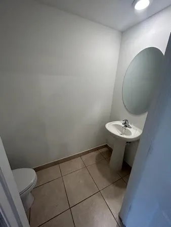 a bathroom with a sink a toilet and mirror