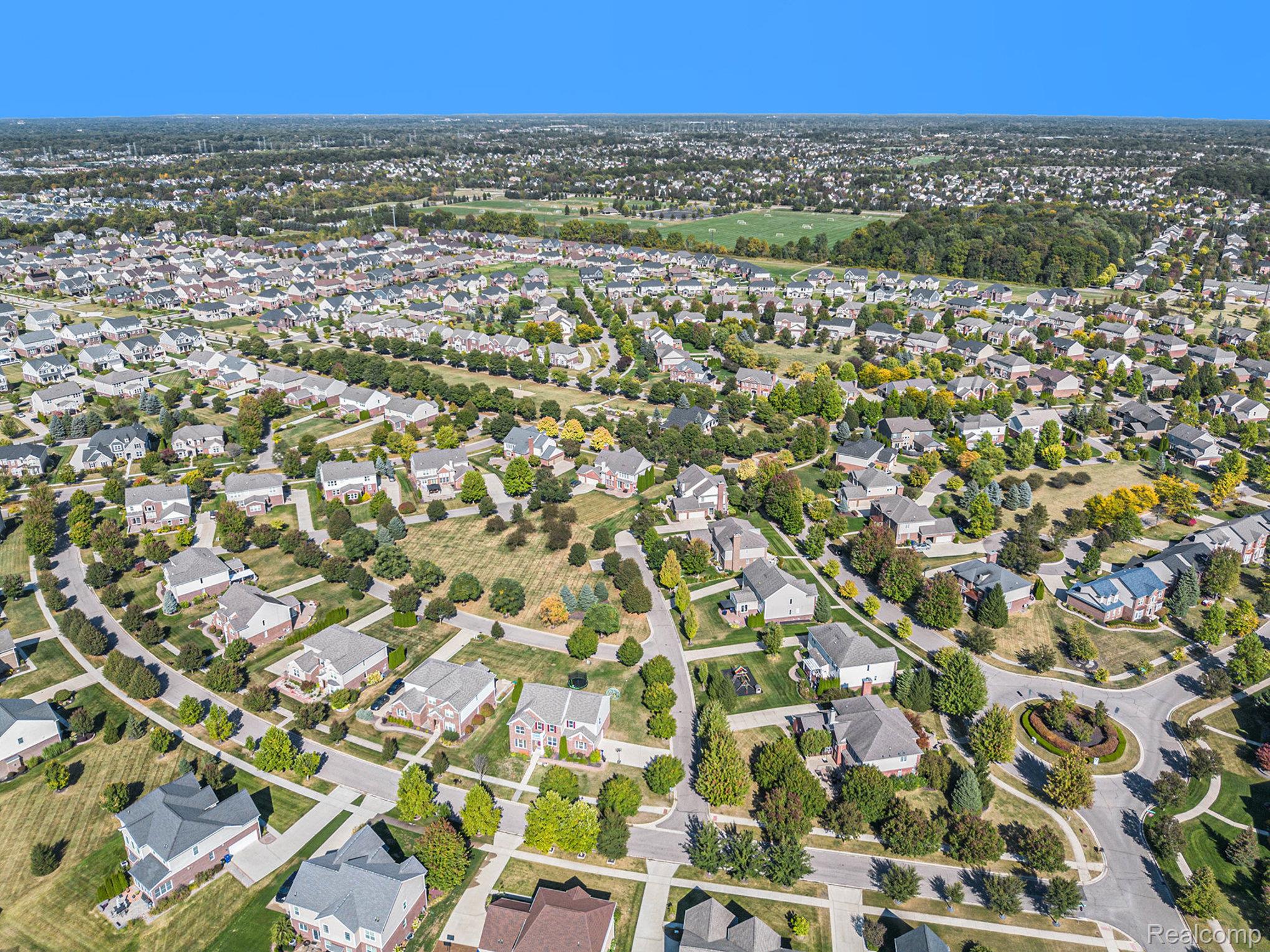 50873 Scarborough Road Canton, MI 48188 - Photo 33 of 33 Expansive aerial perspective showcasing a residential neighborhood with numerous single-family homes, mature trees, and paved roadways