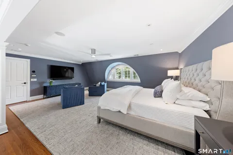 a spacious bedroom with a bed and a flat screen tv