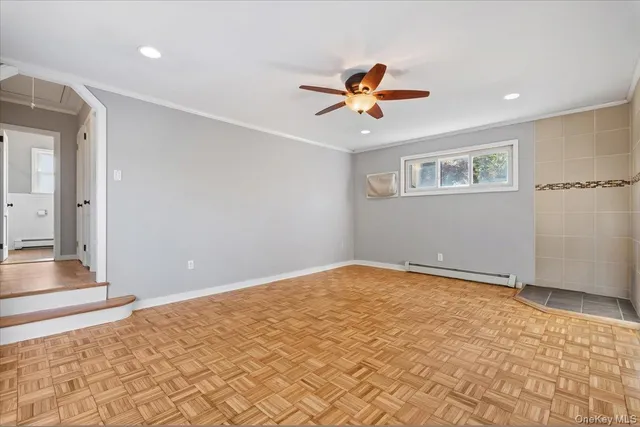 a view of a big room with wooden floor and a chandelier fan