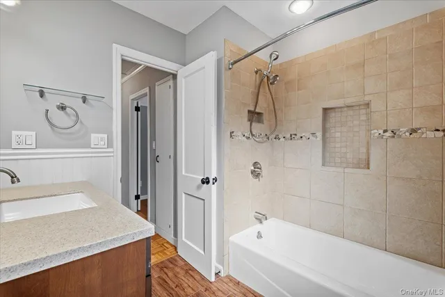 a bathroom with a sink a mirror toilet and bathtub