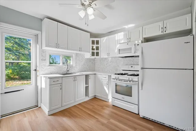 a kitchen with white cabinets and white appliances