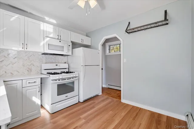 a kitchen with white cabinets and white appliances