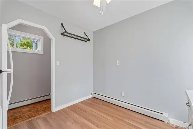a view of an empty room with closet and a window