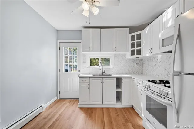 a kitchen with granite countertop a sink cabinets stainless steel appliances and a counter top space