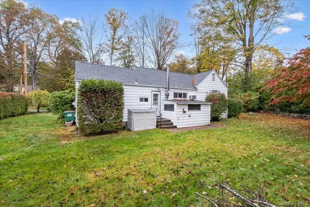 a view of a house with a big yard and large trees