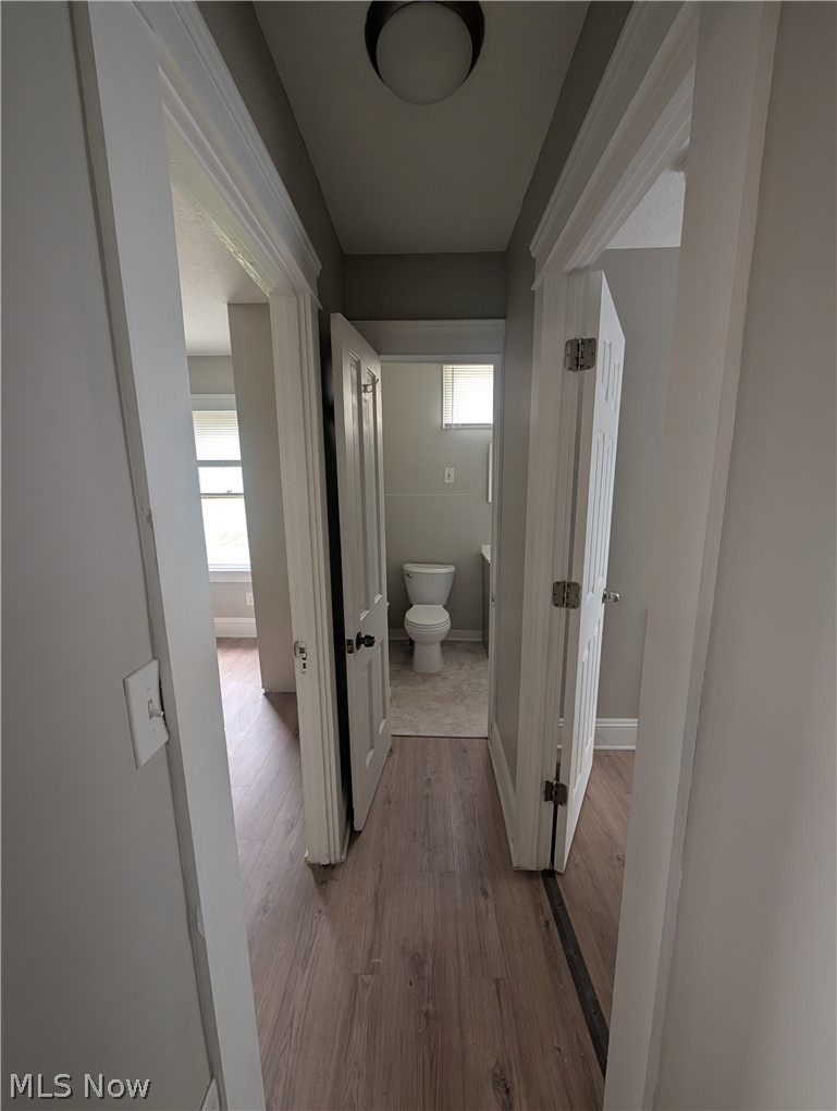 7515 Ottawa Road Cleveland, OH 44105 - Photo 15 of 21 Hallway featuring wood-finish flooring, white trim, and doors leading to additional rooms