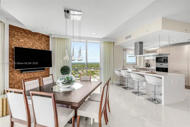 a large white kitchen with a sink a window and stainless steel appliances