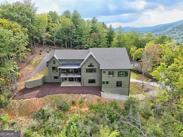 an aerial view of a house with swimming pool patio and outdoor seating