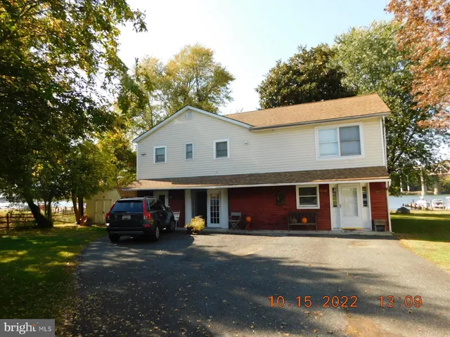 a front view of a house with a garden and trees