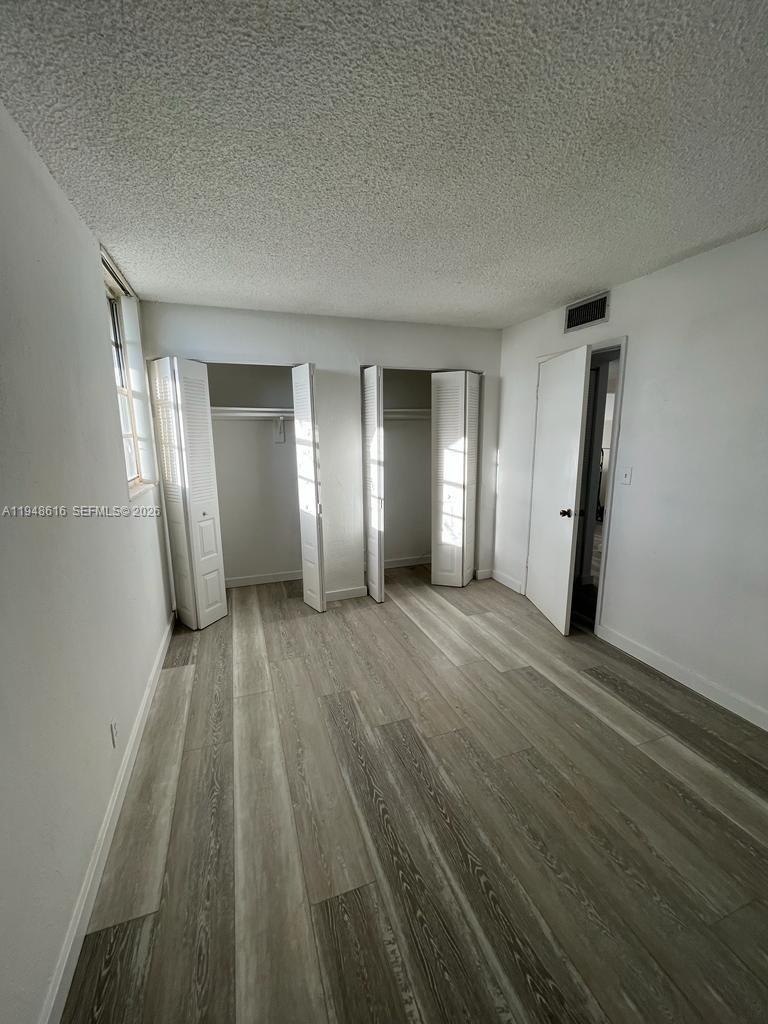 4550 Northwest 9th Street, Unit 801E Miami, FL 33126 - Photo 12 of 31 a view of empty room with wooden floor