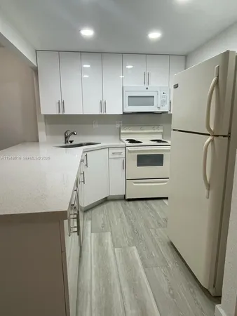 a kitchen with a white cabinets and white appliances