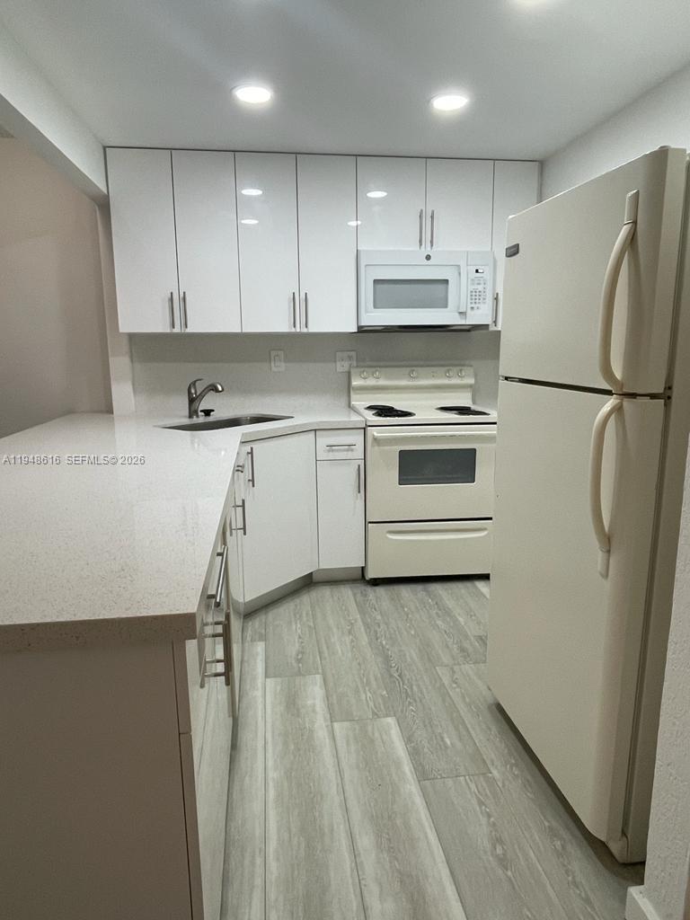 4550 Northwest 9th Street, Unit 801E Miami, FL 33126 - Photo 2 of 31 a kitchen with a white cabinets and white appliances
