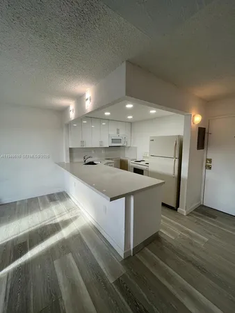 a large white kitchen with a stove a sink and a refrigerator