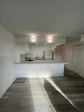 a view of kitchen with stainless steel appliances cabinets and wooden floor