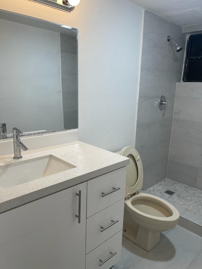 4550 Northwest 9th Street, Unit 801E Miami, FL 33126 - Photo 9 of 31 a bathroom with a sink a toilet and a mirror