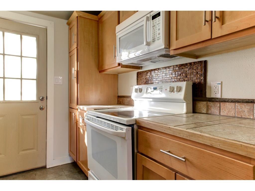 2103 Harrison Avenue Fort Worth, TX 76110 - Photo 12 of 19 a kitchen with stainless steel appliances granite countertop a stove and a refrigerator