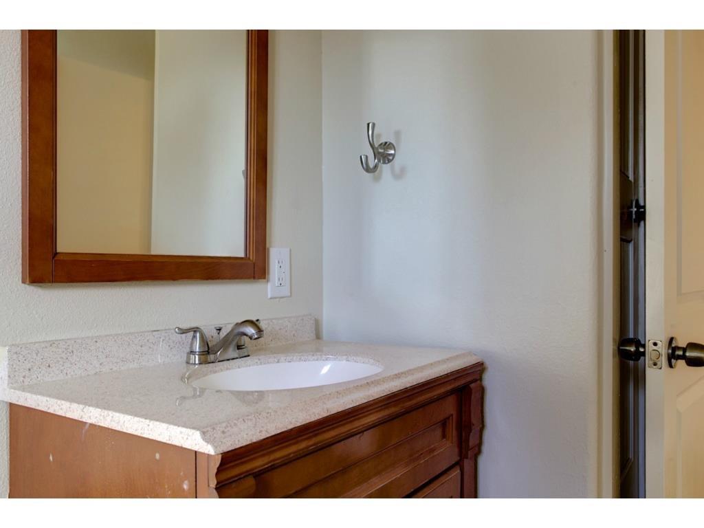 2103 Harrison Avenue Fort Worth, TX 76110 - Photo 17 of 19 a bathroom with a sink vanity and a mirror