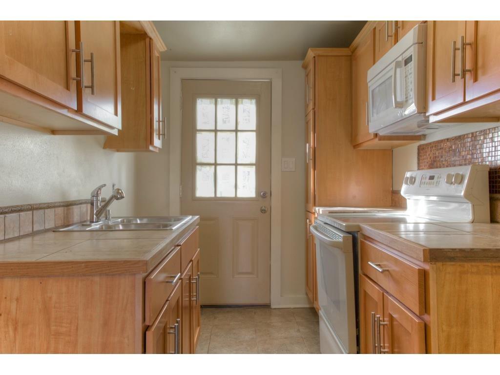 2103 Harrison Avenue Fort Worth, TX 76110 - Photo 10 of 19 a kitchen with kitchen island granite countertop a sink stainless steel appliances and cabinets