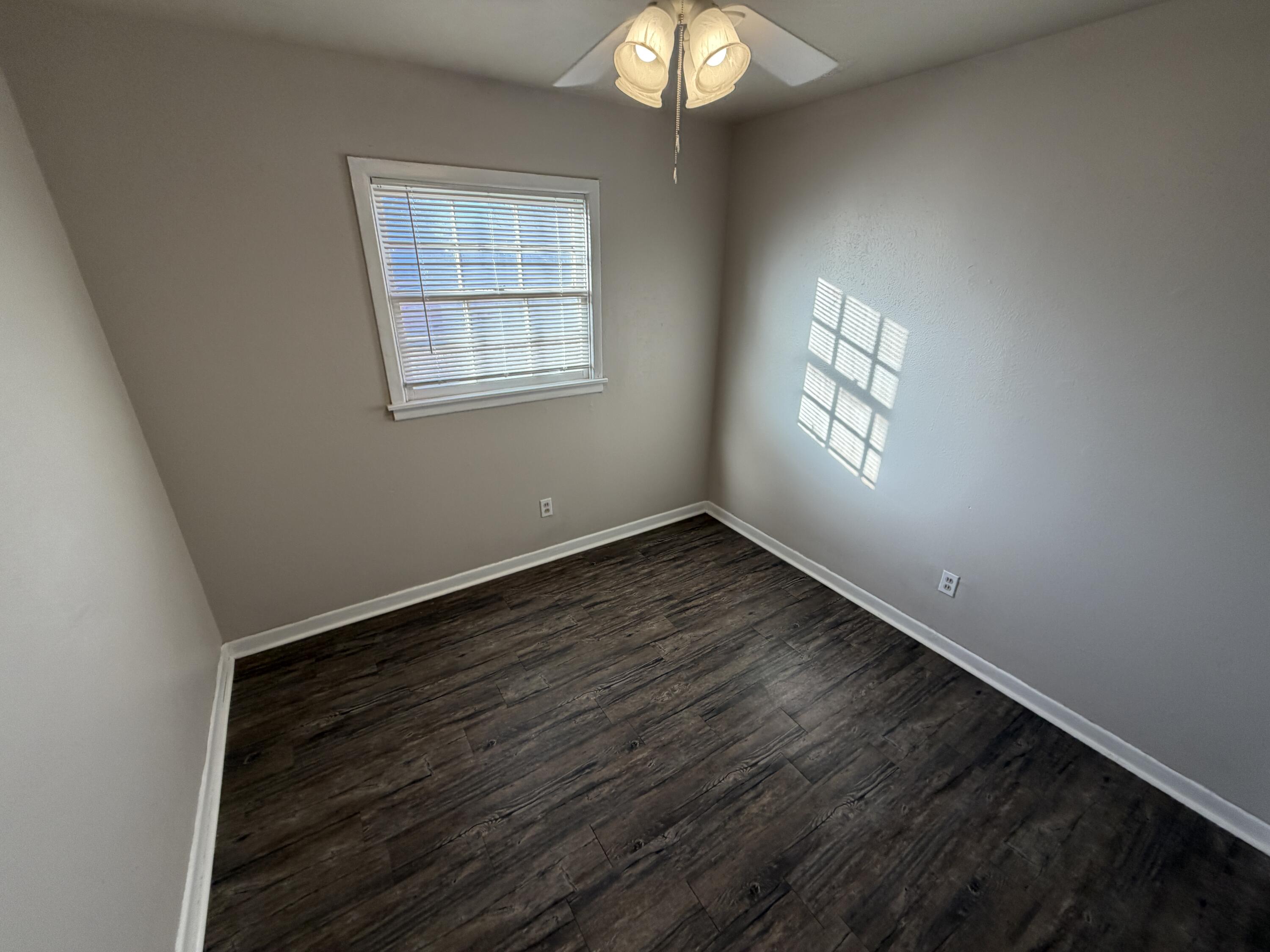 5114 46th Street Lubbock, TX 79414 - Photo 13 of 16 a view of an empty room with wooden floor and a window