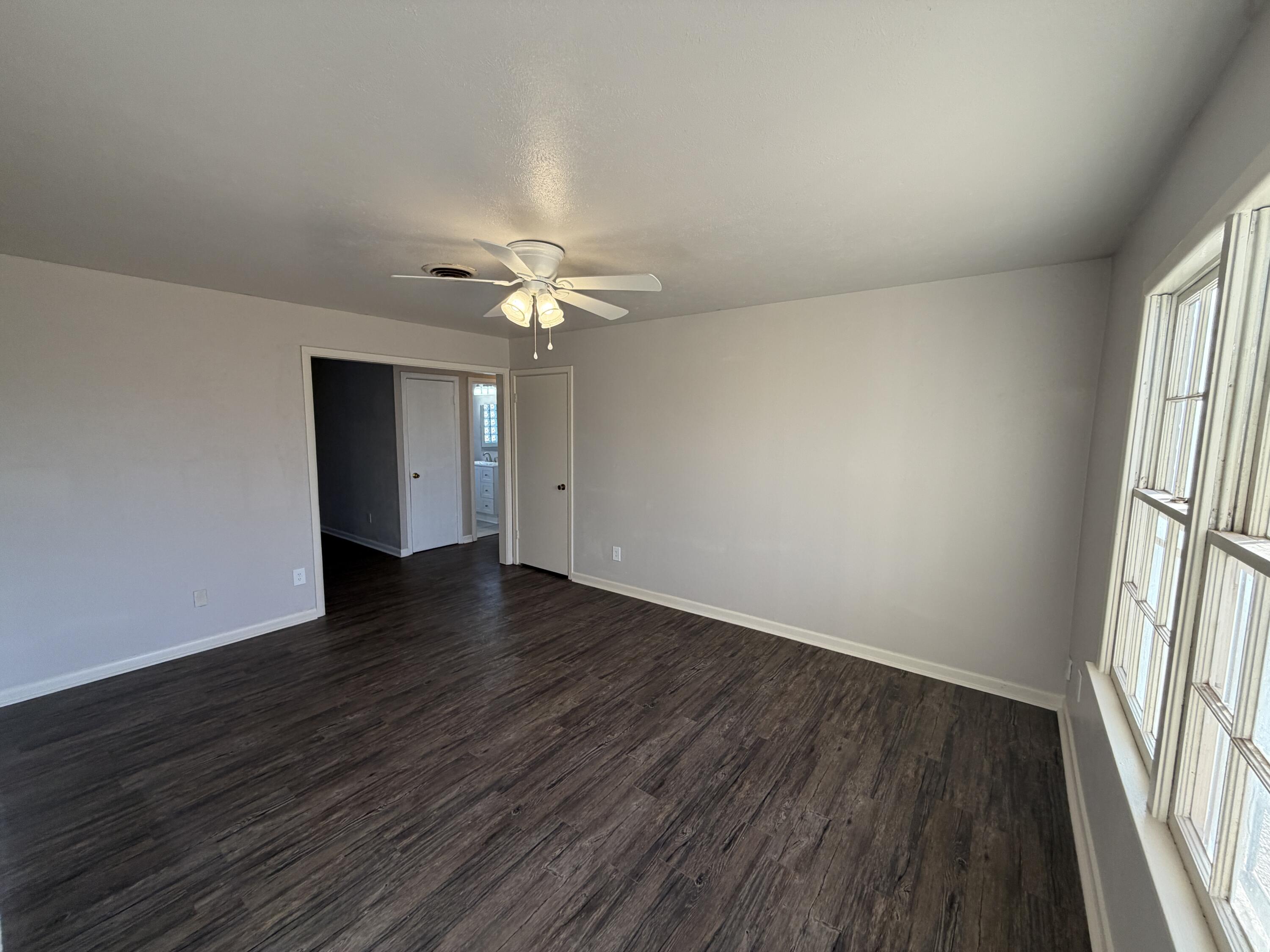 5114 46th Street Lubbock, TX 79414 - Photo 2 of 16 an empty room with wooden floor and window
