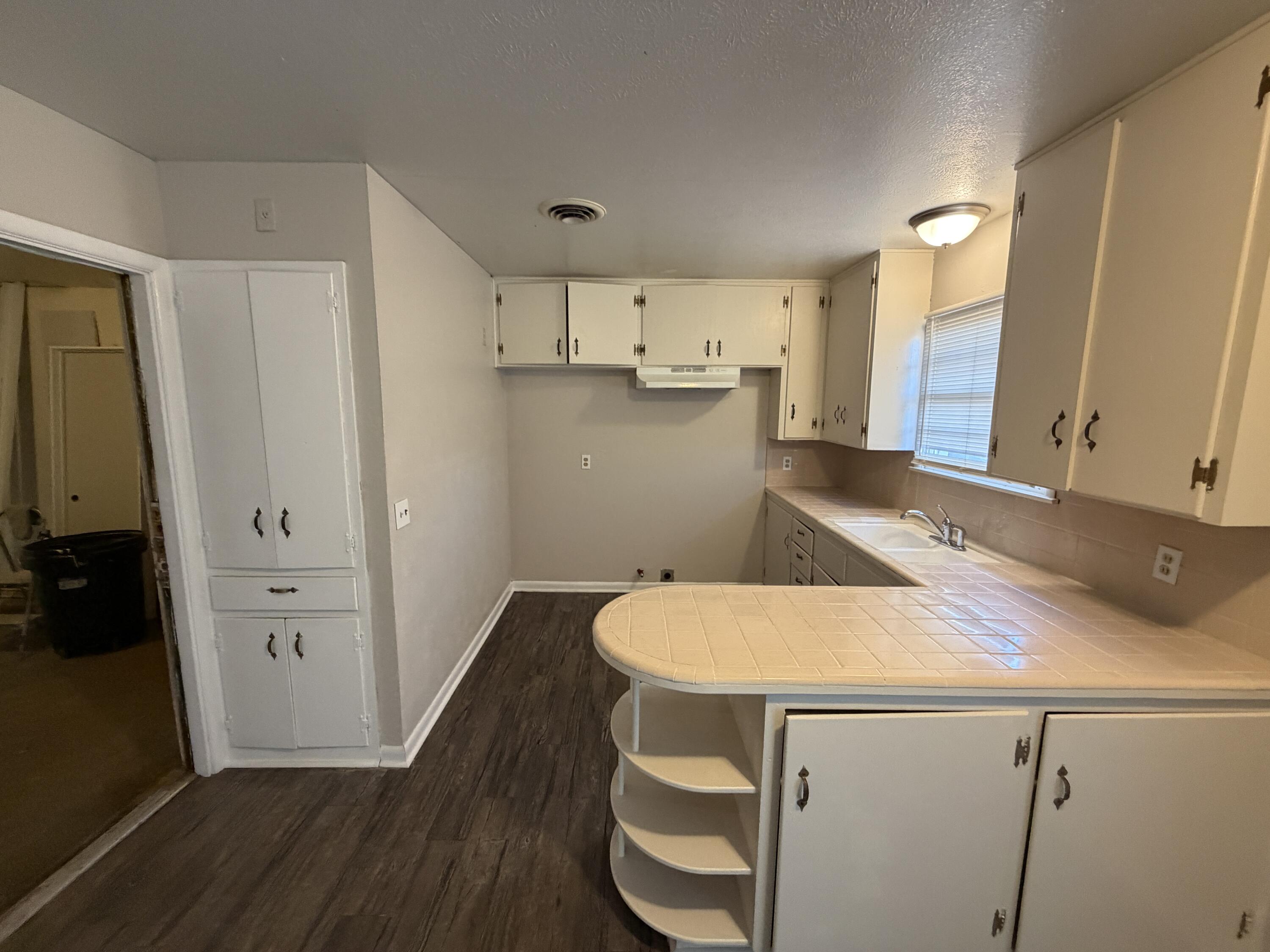 5114 46th Street Lubbock, TX 79414 - Photo 3 of 16 a kitchen with a sink and wooden floor
