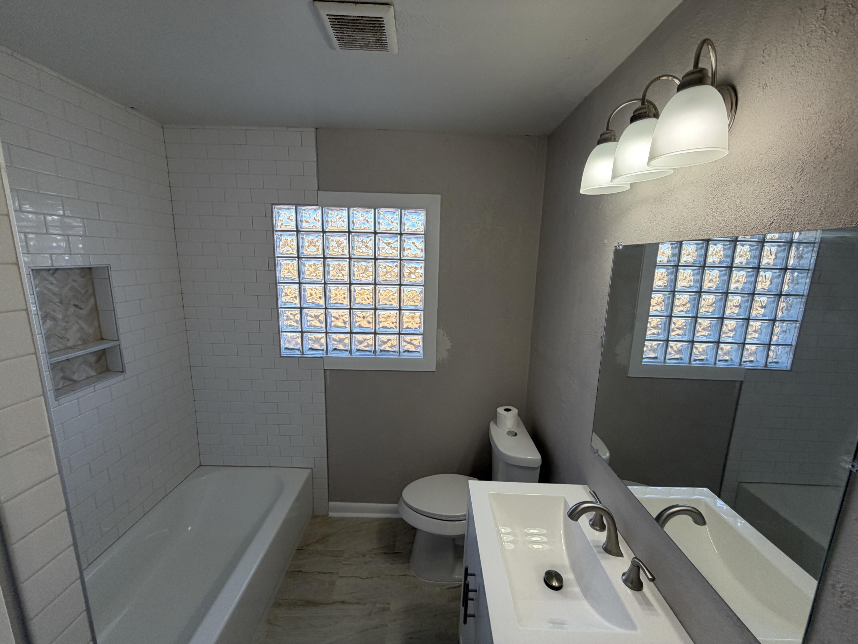 5114 46th Street Lubbock, TX 79414 - Photo 6 of 16 a bathroom with a bathtub sink vanity and toilet