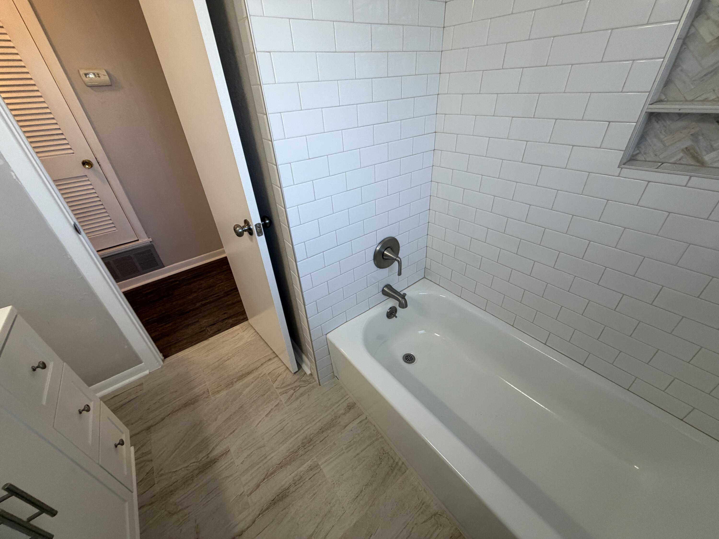 5114 46th Street Lubbock, TX 79414 - Photo 7 of 16 a bathroom with a tub a sink and a shower