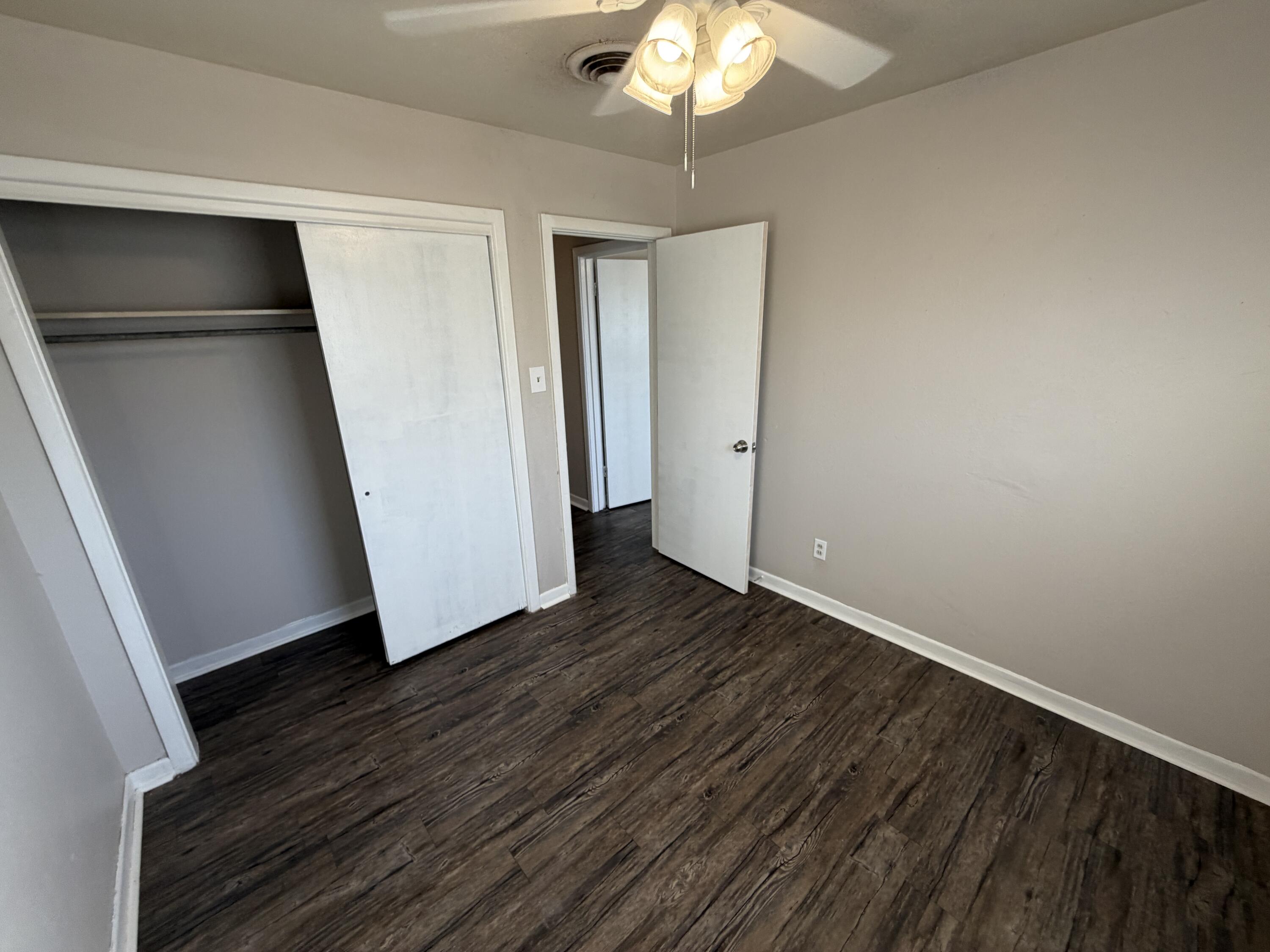 5114 46th Street Lubbock, TX 79414 - Photo 8 of 16 an empty room with wooden floor and chandelier