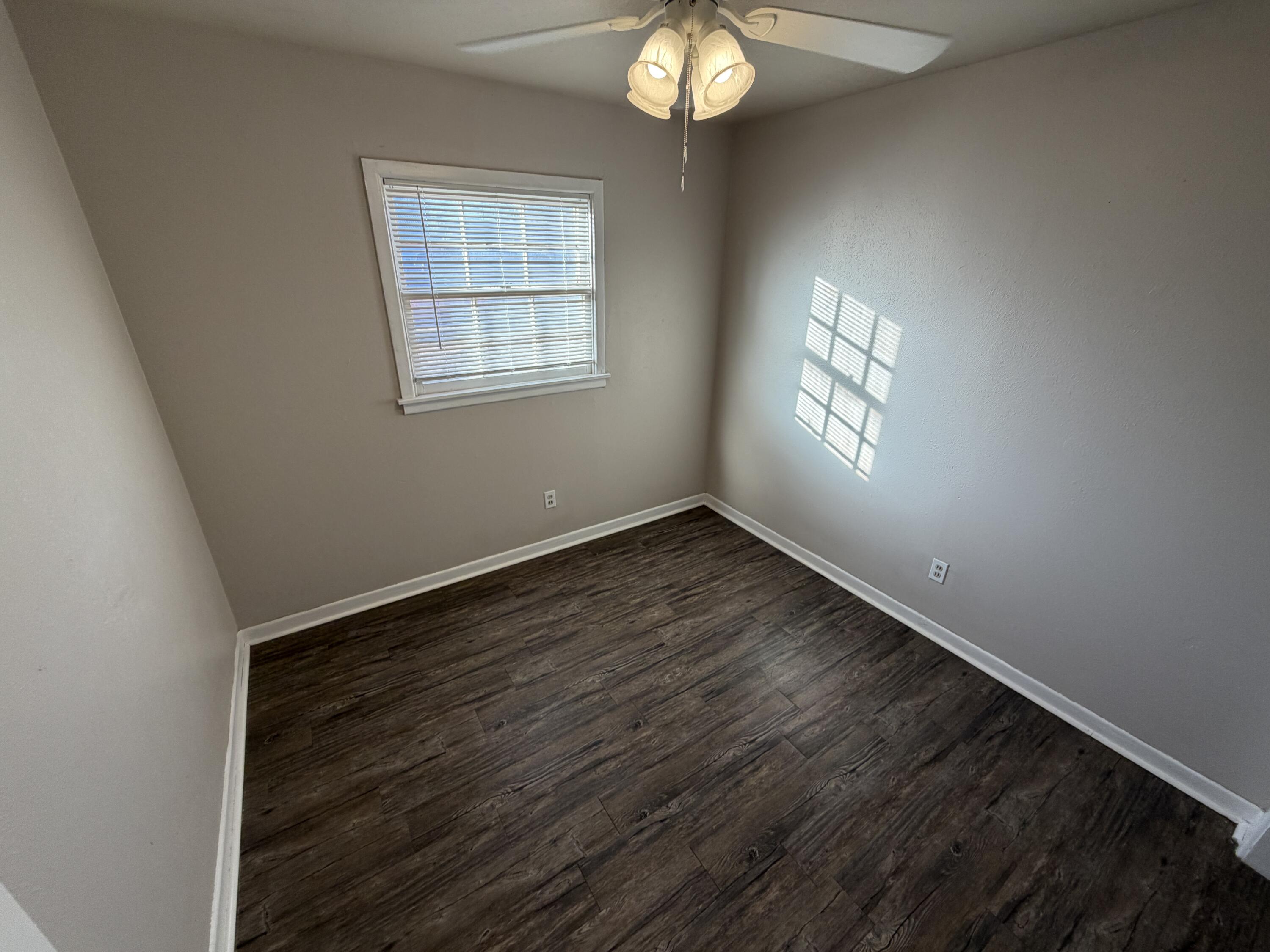 5114 46th Street Lubbock, TX 79414 - Photo 9 of 16 an empty room with wooden floor and windows