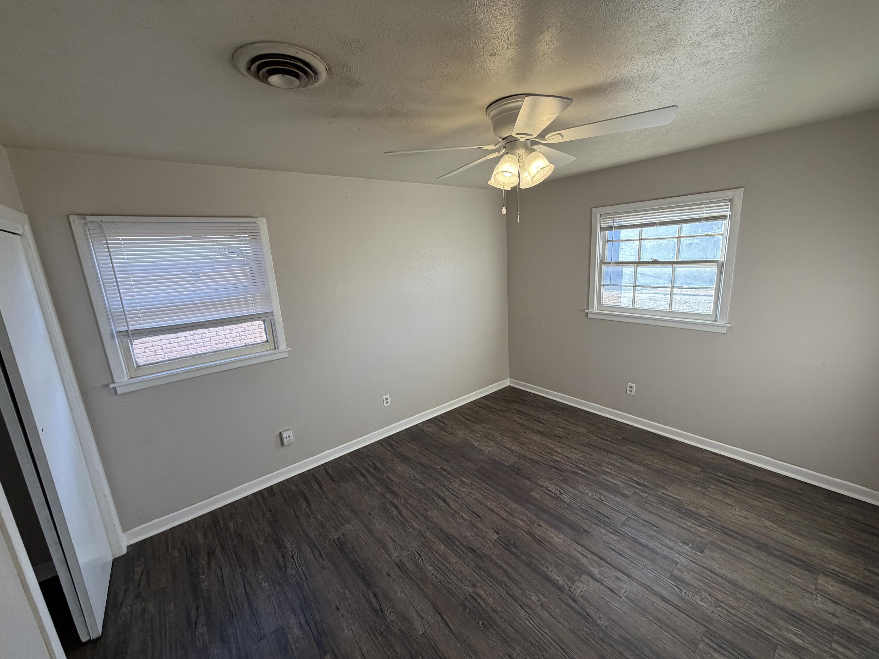 5114 46th Street Lubbock, TX 79414 - Photo 10 of 16 an empty room with wooden floor fan and windows
