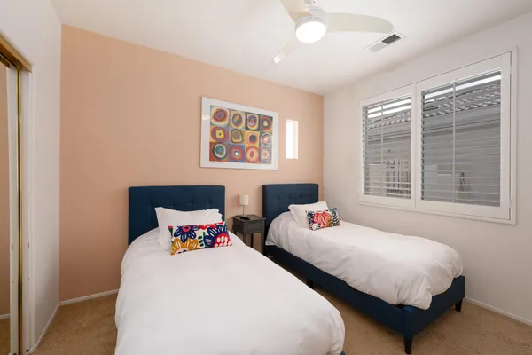 a bedroom with two bed and a window