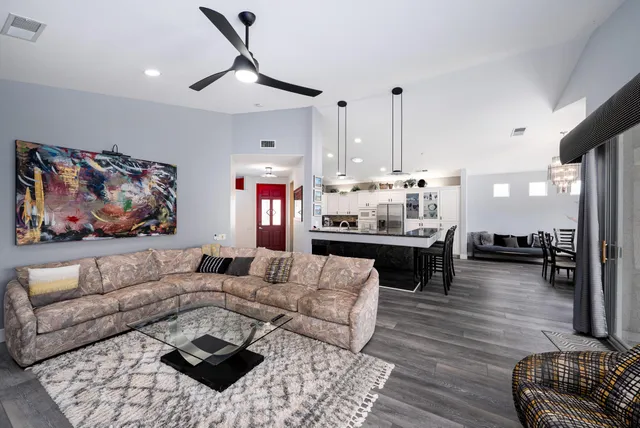 a large kitchen with stainless steel appliances kitchen island granite countertop a stove and white cabinets