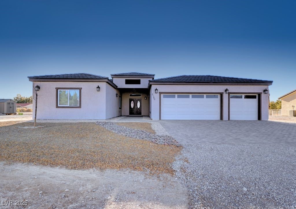 2660 South Blagg Road Pahrump, NV 89048 - Photo 1 of 1 Prairie-style home with stucco siding, decorative driveway, and a garage