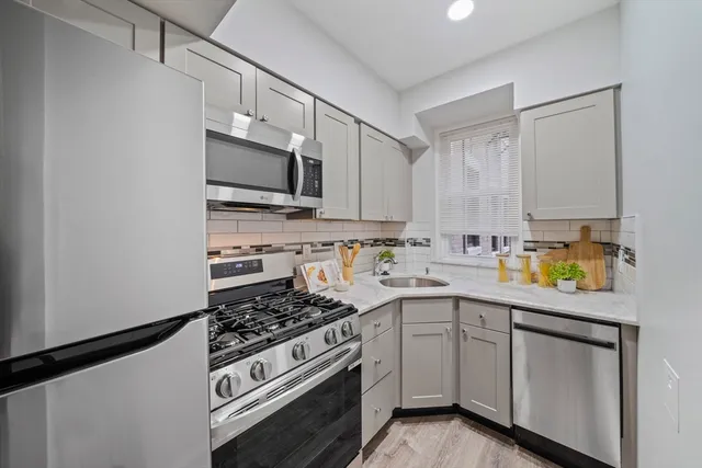 a kitchen with cabinets stainless steel appliances and a counter space
