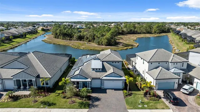 an aerial view of a house with a garden and lake view