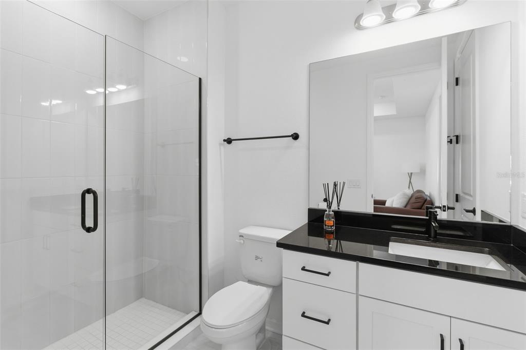 19912 Bridgetown Loop Venice, FL 34293 - Photo 25 of 49 a bathroom with a granite countertop sink a toilet a mirror and shower